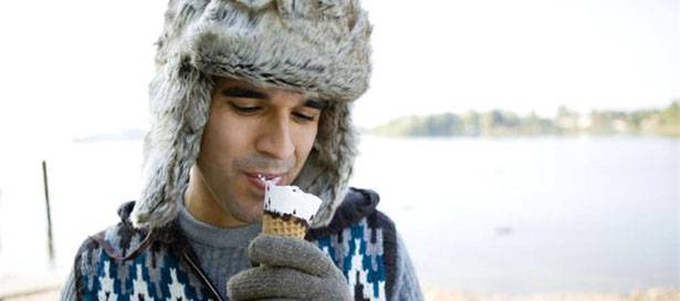 young man eating ice cream in winter