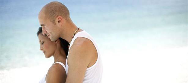 Man and Woman Under Beach Umbrella