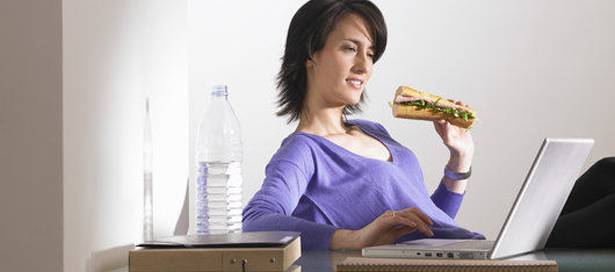 Woman at her desk, eating