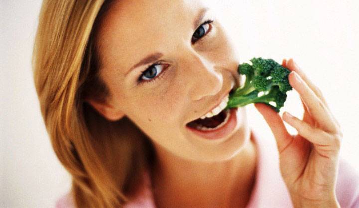 Blonde young woman with broccoli --- Image by © Michael A. Keller/Corbis