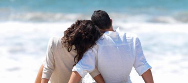 Rear view of a couple sitting on beach