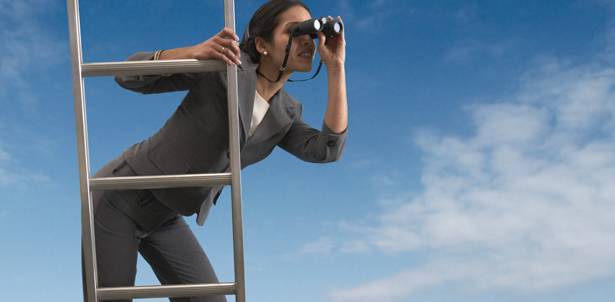 Businesswoman standing on a ladder looking through binoculars