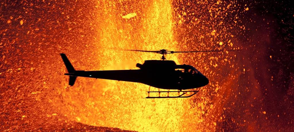 A helicopter flies with a cameraman close to the eruption.