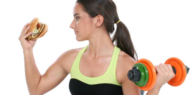 Beautiful Teen Girl Holding Colorful Weights And A Giant Cheeseb