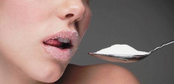 Woman eating spoon of sugar