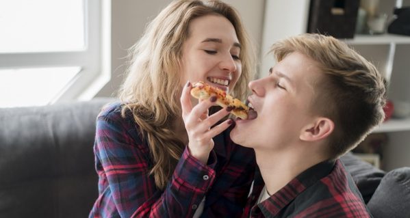 couple-eating-pizza-home_23-2148540314