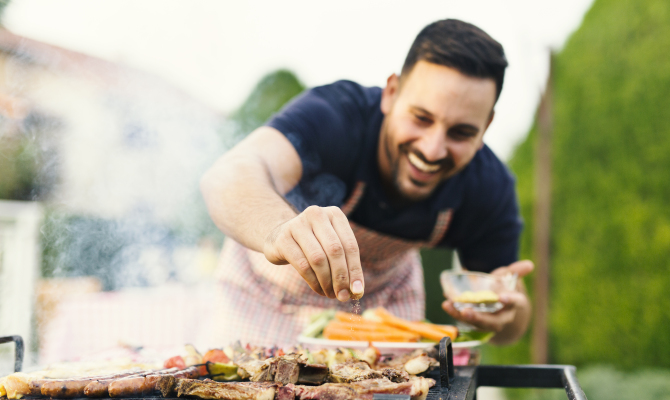 Smiling,Man,Seasoning,Meat,On,The,Grill