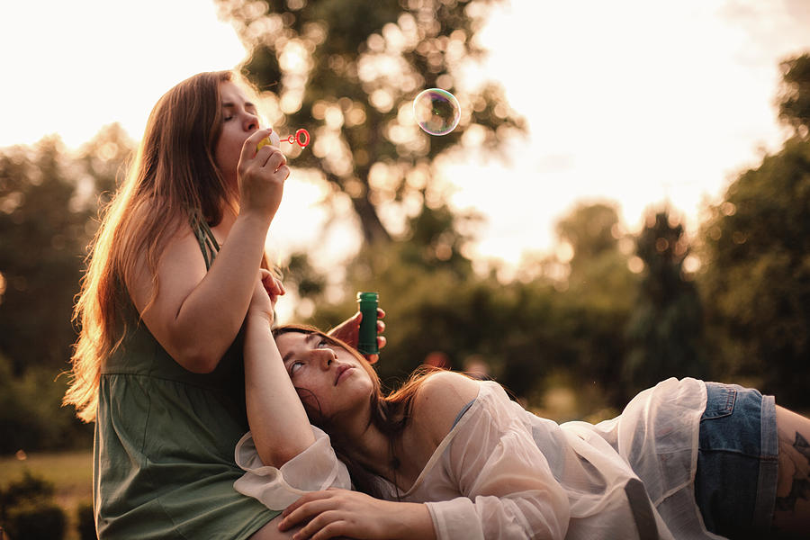 4-couple-playing-with-bubbles-while-relaxing-in-park-in-summer-cavan-images