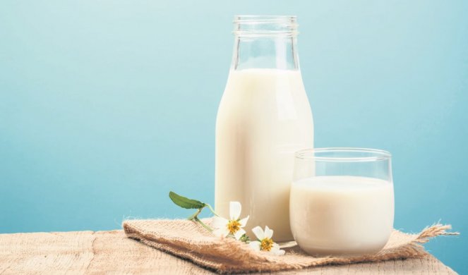 504302_xstock-photo-a-bottle-of-milk-and-glass-of-milk-on-a-wooden-table-on-a-blue-background-568076731_f