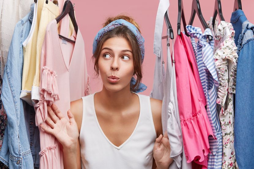 attractive-woman-dressed-casually-looking-with-doubts-aside-while-standing-near-hangers-with-clothes-thinking-what-dress-business-meeting-with-companions-woman-fashion-having-many-clothes-830x0