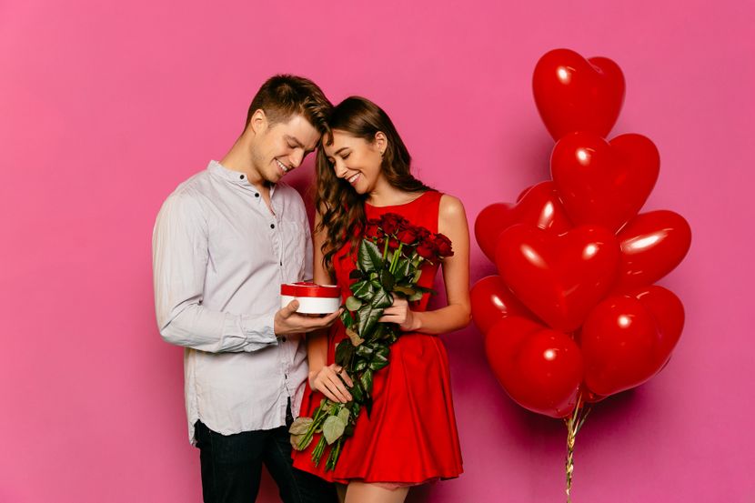 handsome-man-attractive-woman-looking-box-with-gift-red-roses-830x0