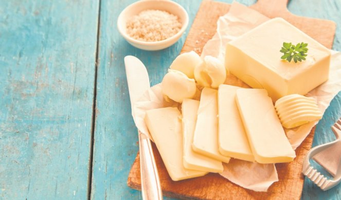 491710_xstock-photo-block-of-fresh-butter-sliced-on-wooden-cutting-board-against-blue-table-1120312025_f