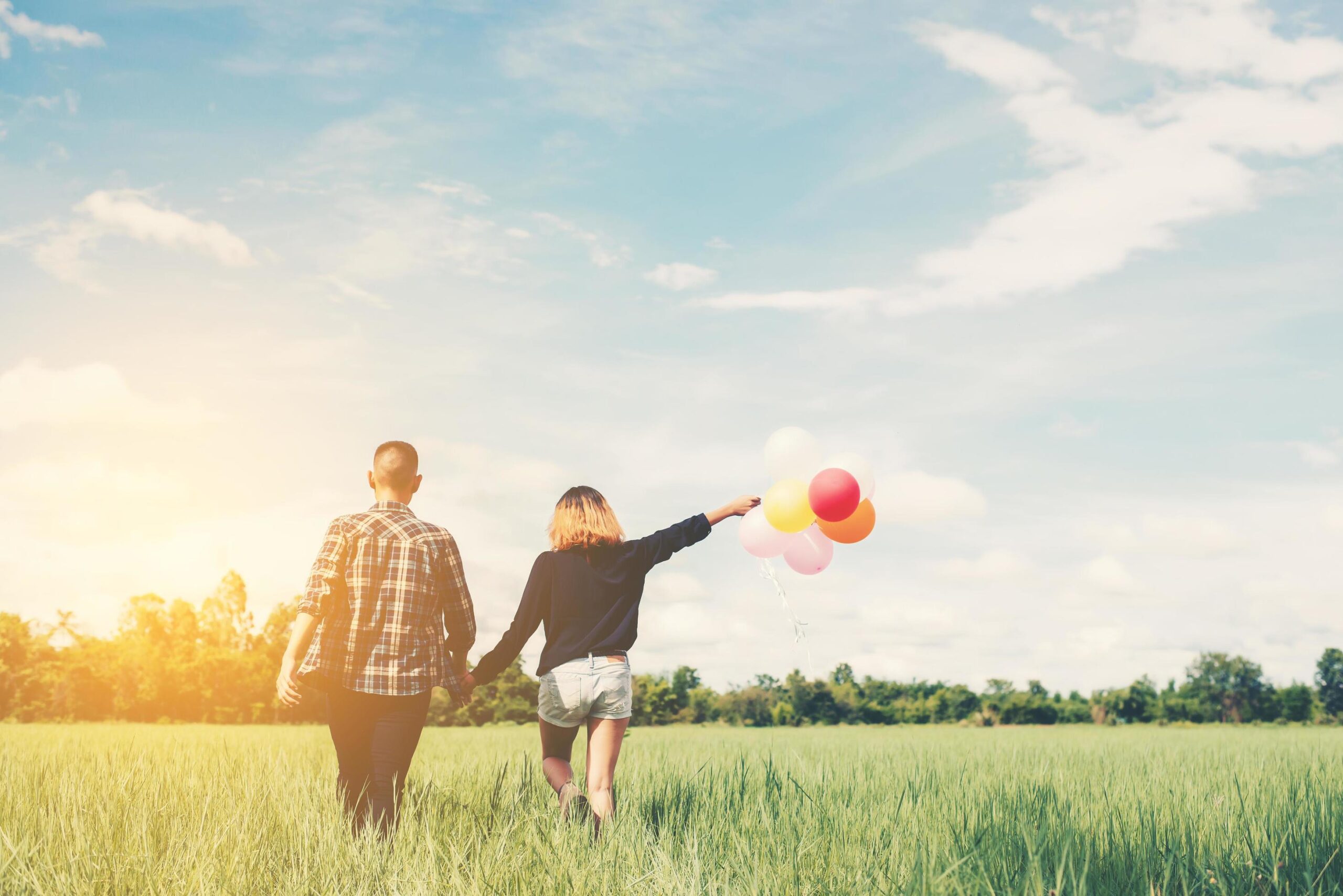 back-of-happy-young-asian-couple-holding-balloon-and-walk-together-free-photo