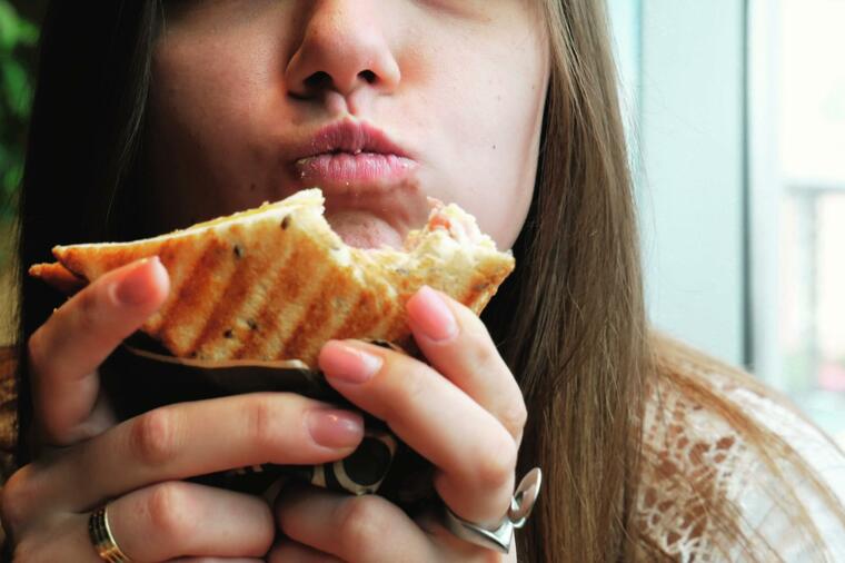 340433_glavna--stockphotocloseupportraitofyounghungrywomanwithpleasureeatscrisptoastinacafefastfood1426384196_ls