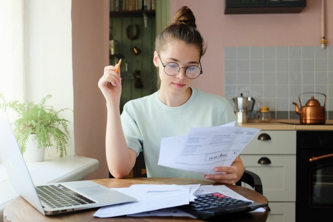 Indoor picture of young European female sitting at home at table