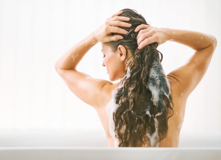 Young woman washing hair. rear view
