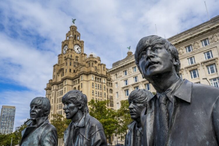 The bronze statue of the Beatles on the Liverpool Waterfront with Liver Building, Liverpool, Merseyside