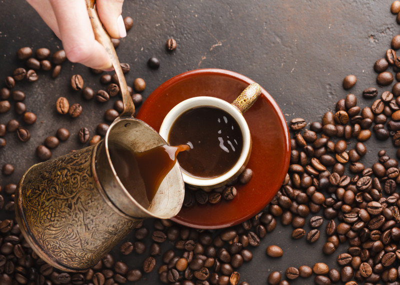 top-view-hand-pouring-coffee-into-cup