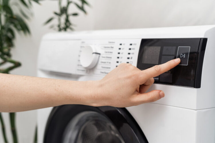 Selective,Focus,On,Cropped,Woman,Hand,Select,Settings,For,Laundry