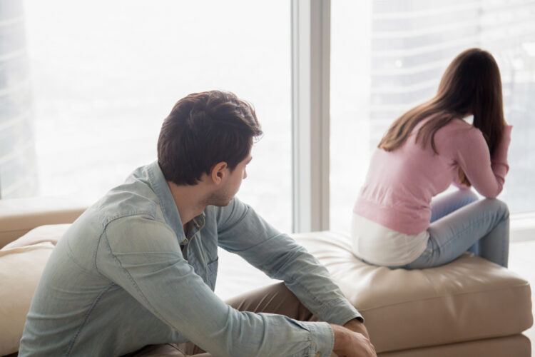 Young,Couple,Sitting,Apart,Indoors,After,Quarrel.,Offended,Girl,Ignoring