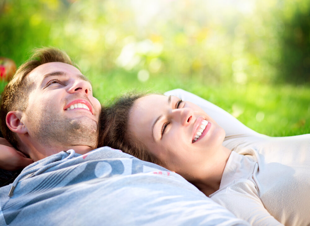 Happy,Smiling,Couple,Relaxing,On,Green,Grass.park.young,Couple,Lying,On