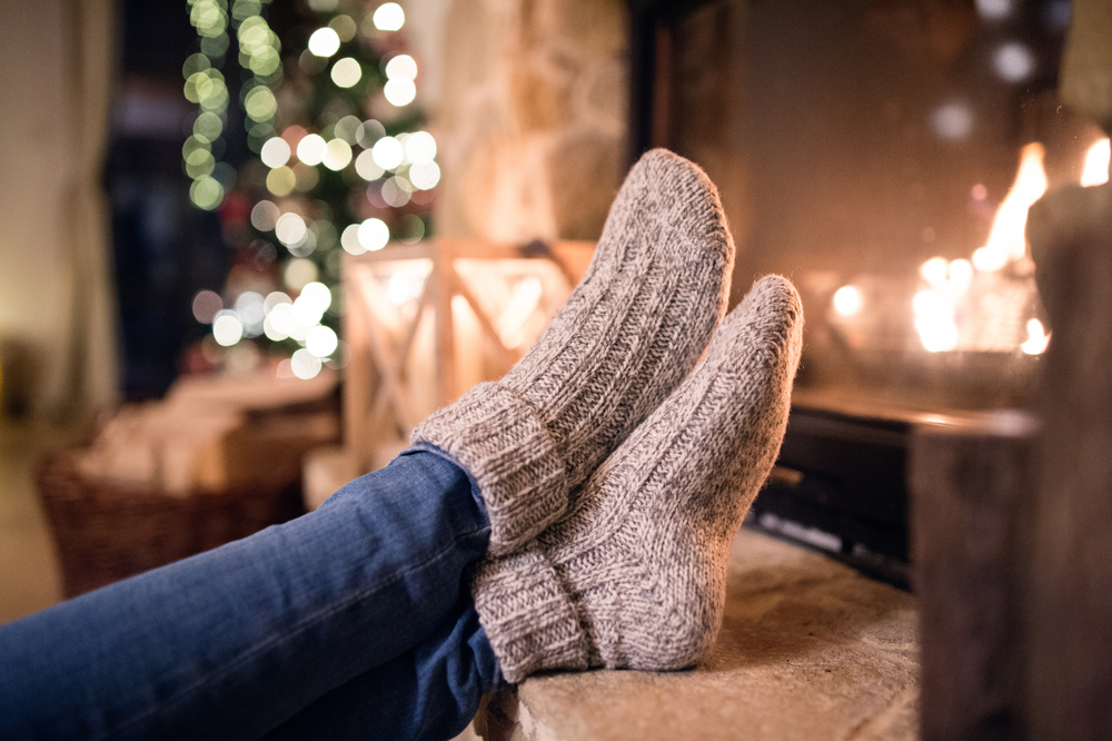 Feet,Of,Unrecognizable,Woman,In,Socks,By,The,Christmas,Fireplace