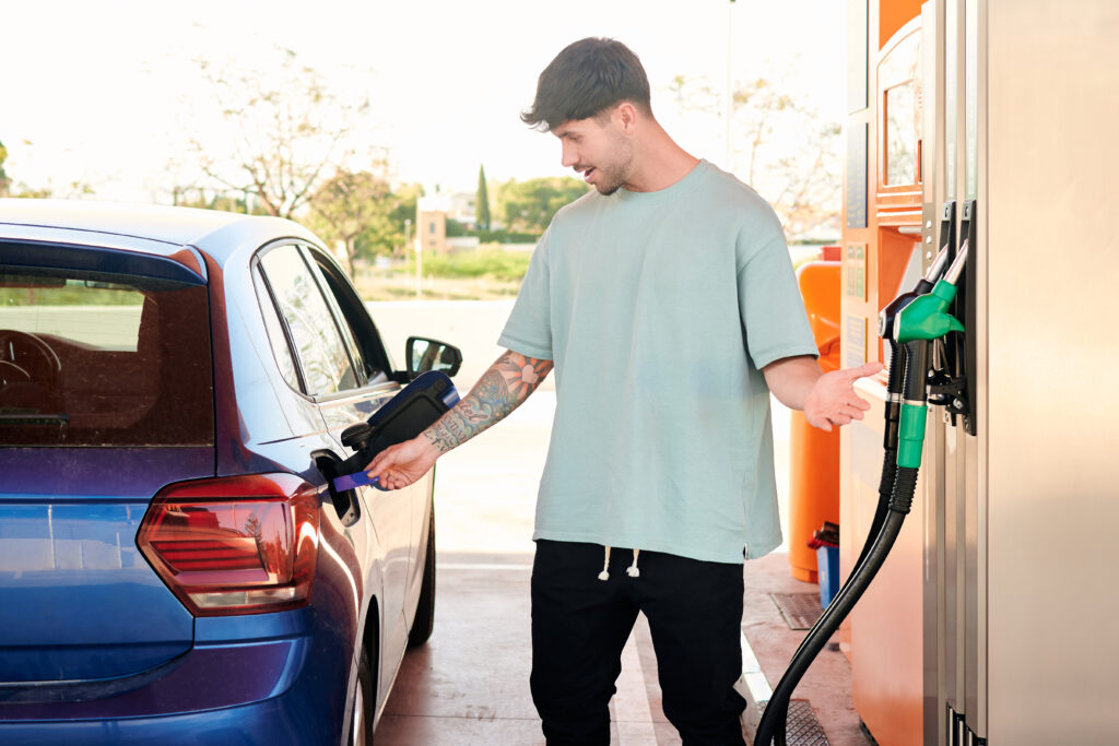 Young man with credit card surprised by gas prices