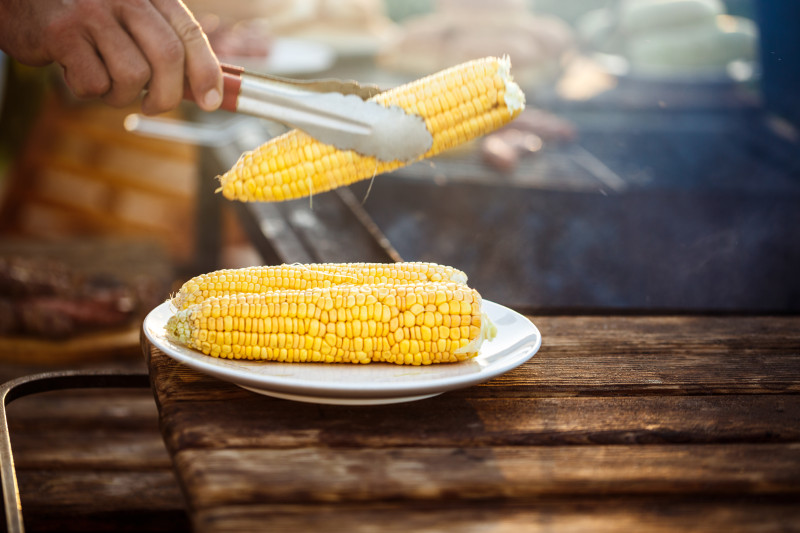 young-man-roasting-corn-grill